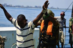 莫桑比克武装部队的一名登船队员在演习中搜查一名模拟的非法渔民。由技术中士查德·汤普森(https://www.dvidshub.net/image/1053816)[公共领域]，通过维基共享资源